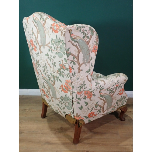 91 - A wingback Armchair with bird of paradise design cover mounted upon shell carved cabriole front supp... 