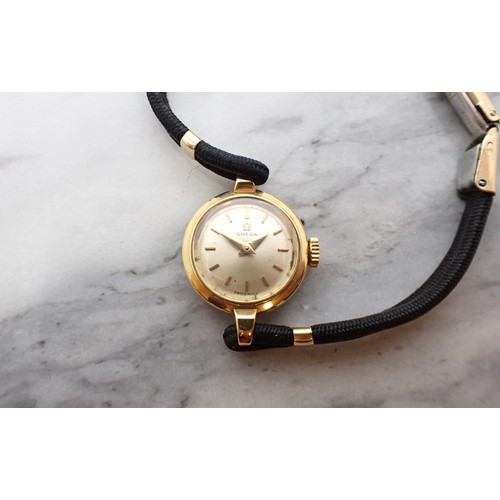 152 - A lady's Omega manual Wristwatch the brushed effect champagne dial with hourly baton markers in 18ct... 