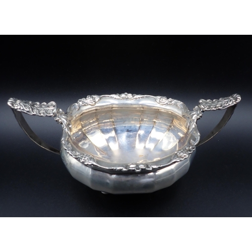 103 - A George V silver two-handled Sugar Bowl and Milk Jug of panelled form with floral scroll borders an... 