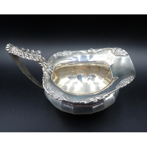 103 - A George V silver two-handled Sugar Bowl and Milk Jug of panelled form with floral scroll borders an... 