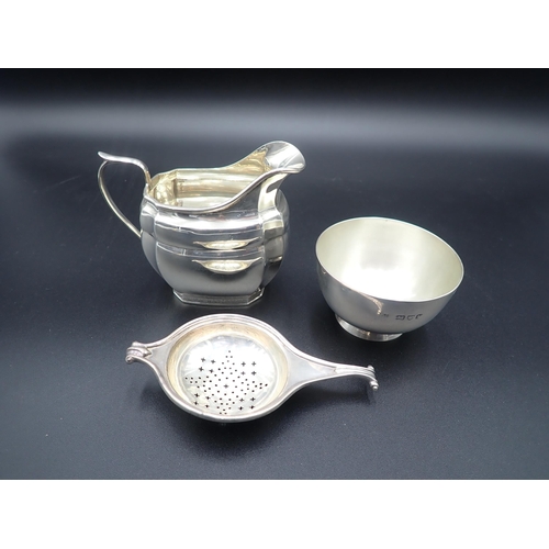 113 - A George VI silver panelled Milk Jug, Birmingham 1940, a Tea Strainer, Birmingham 1926, and a plain ... 