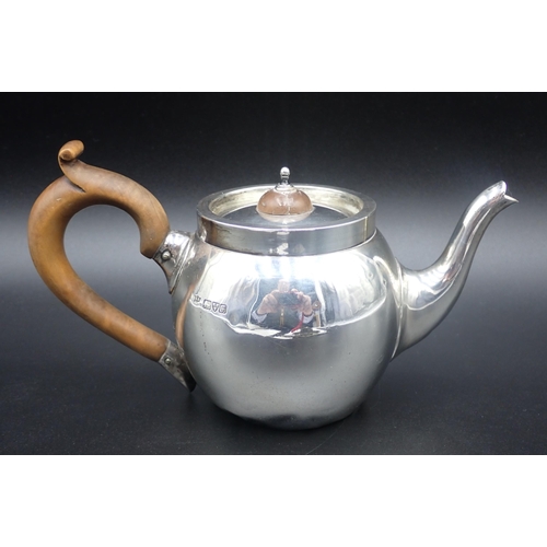 149 - An Edward VII Bachelor's silver bullet shape Teapot with pear wood handle, Chester 1906, dented