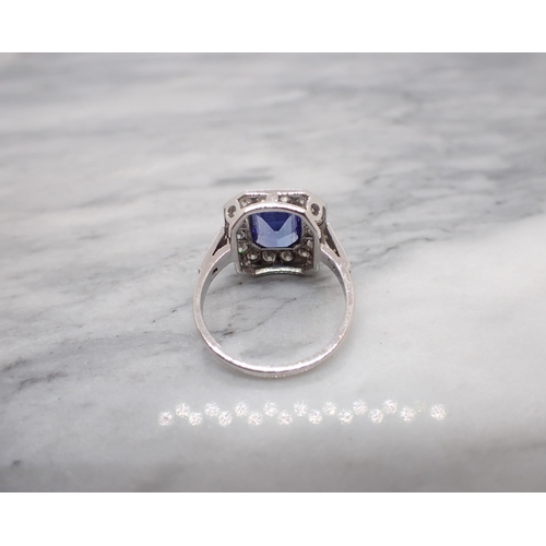 175 - An Art Deco style Tanzanite and Diamond Cluster Ring millegrain-set step-cut tanzanite within a fram... 