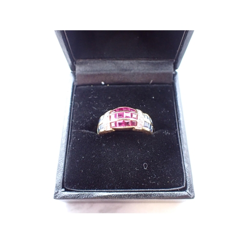 185 - A Ruby, Diamond and Sapphire Ring the wide band channel-set three rows of calibré-cut rubies between... 