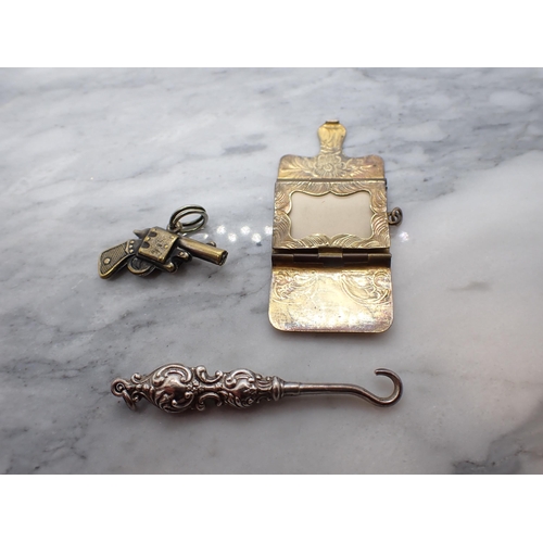 199 - A gilt metal Watch Key formed as a pistol inset compass, a gilt metal Stamp Envelope and a small sil... 