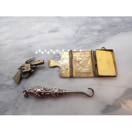 199 - A gilt metal Watch Key formed as a pistol inset compass, a gilt metal Stamp Envelope and a small sil... 