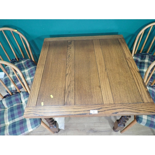 45 - An oak draw leaf Dining Table and four Ercol style Kitchen Chairs