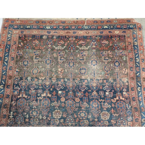 10 - An old Persian woollen Rug with stylised flower design on blue ground within multiple borders 6ft 2i... 