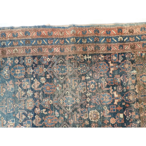 10 - An old Persian woollen Rug with stylised flower design on blue ground within multiple borders 6ft 2i... 