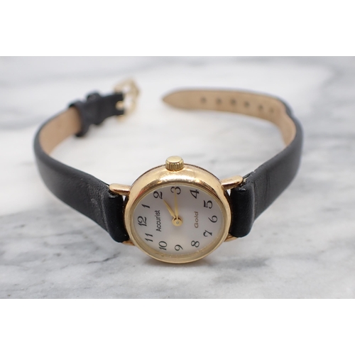 154 - A lady's Accurist quartz Wristwatch the white dial with arabic numerals in 9ct gold case on black le... 