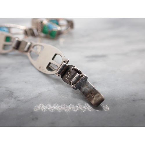 167 - A James Fenton Secessionist Bracelet having elliptical pierced silver links each with blue and green... 