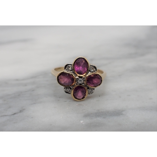 170 - A Diamond and Garnet flower Cluster Ring pavé-set five eight-cut diamonds interspersed with four rub... 