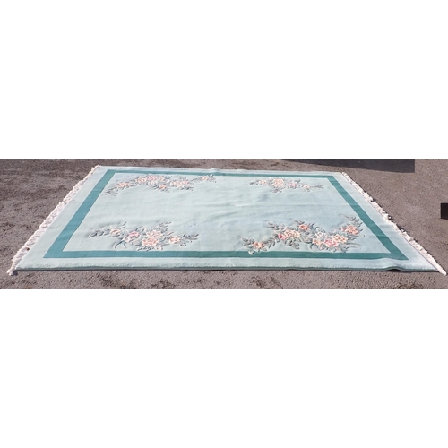 40 - A large modern Chinese Carpet on light blue ground with floral decorations.