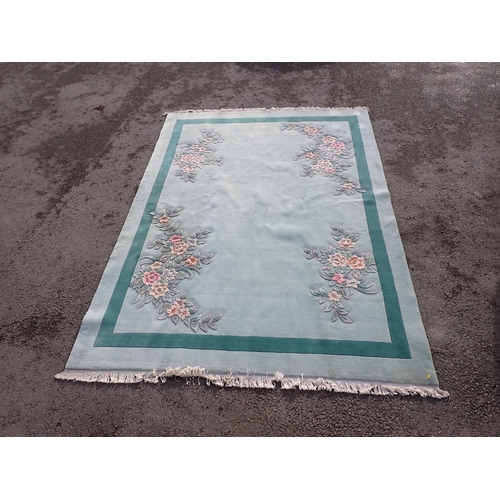 40 - A large modern Chinese Carpet on light blue ground with floral decorations.