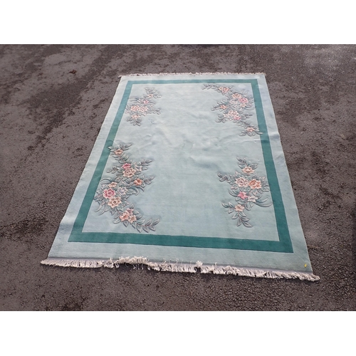 40 - A large modern Chinese Carpet on light blue ground with floral decorations.