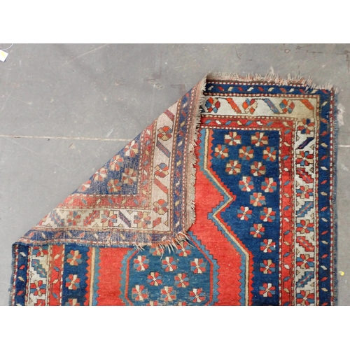 43 - A Kazak style Rug on blue ground with multi borders and large central motif and geometric designs, 5... 