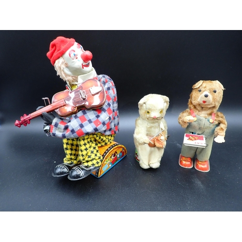 91 - A Japanese tinplate Clown playing a tune on his violin, with original box, and two clockwork Bears, ... 