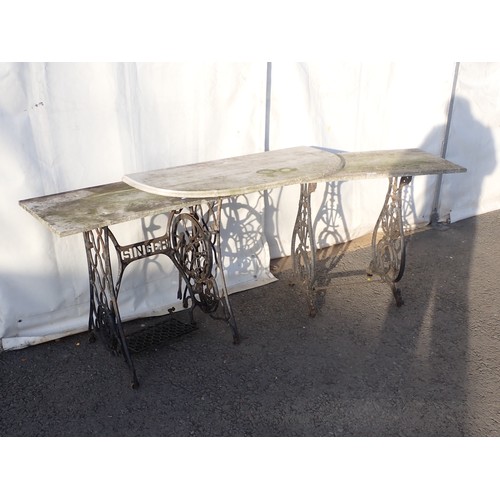 727 - A cast iron singer sewing base with marble top with another cast iron base with marble top and a spa... 