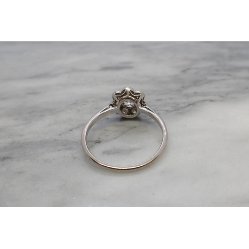 176 - A Diamond Daisy Cluster Ring claw-set old-cut stone within a frame of seven smaller stones, ring siz... 