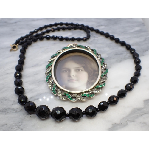 202 - A vintage Portrait medallion having twisted frame set green and white paste and a string of graduate... 