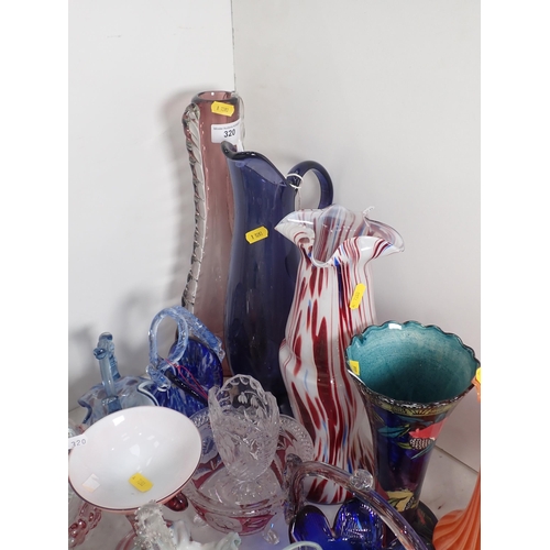 320 - A large quantity of coloured and clear glass including a decanter, vases, bowls, etc