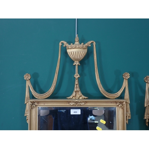 480 - A pair of gilt framed Wall Mirrors with Vase and drape surmounts and oval floral decorations.