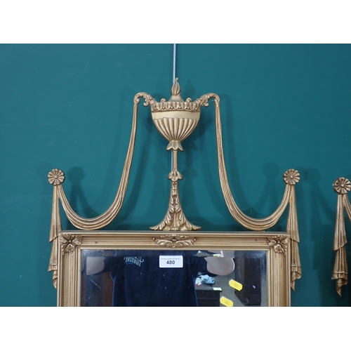 480 - A pair of gilt framed Wall Mirrors with Vase and drape surmounts and oval floral decorations.