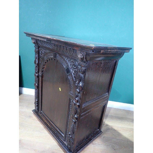 605 - An antique oak Cupboard with single arched carved door, 3ft 1in H x 2ft 10in W