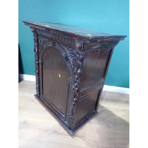 605 - An antique oak Cupboard with single arched carved door, 3ft 1in H x 2ft 10in W