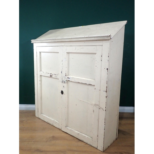 66 - A white painted pine Cupboard, the sloped top above pair of panelled doors enclosing, shelved and pi... 