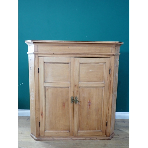 673 - A pine Hanging Corner Cupboard with pair of panelled doors enclosing three fitted shelves, 3ft 7