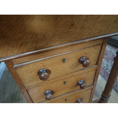 68 - An Oak four Drawer Davenport with turned supports at the front on casters 3ft 2