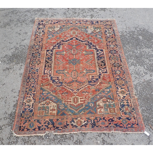 710 - A Persian Rug on red ground with blue multi-borders