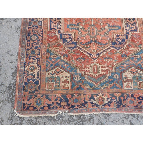 710 - A Persian Rug on red ground with blue multi-borders