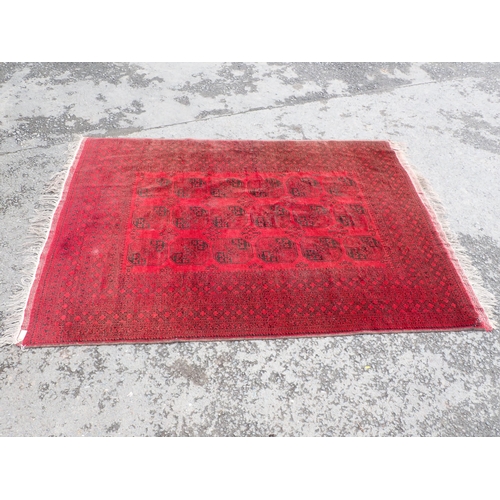 711 - A Turcoman red ground Rug with multi borders with eighteen octagonal geometric designs to centre