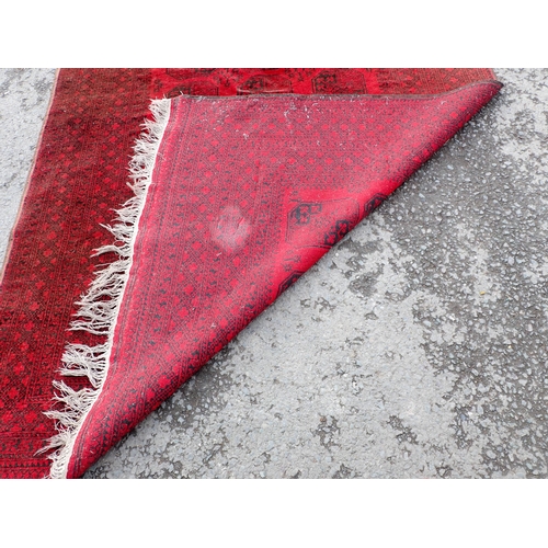 711 - A Turcoman red ground Rug with multi borders with eighteen octagonal geometric designs to centre