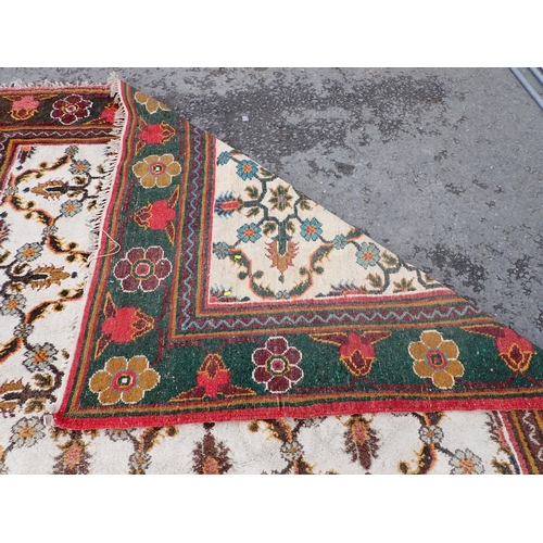 712 - A cream and green ground Rug with floral border and floral central motifs, 9ft 3in x 9ft 1in