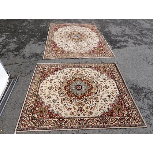 714 - Two modern Persian Rugs on beige ground with multi floral borders, central circular floral motifs, 9... 