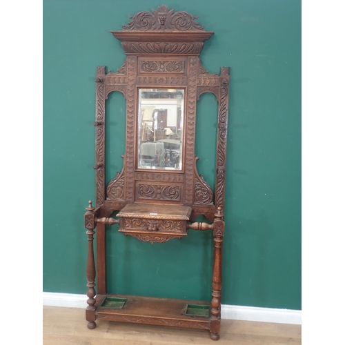 95 - A carved oak mirror back Hall Stand with carved mask and leafage decorations, with single fitted dra... 