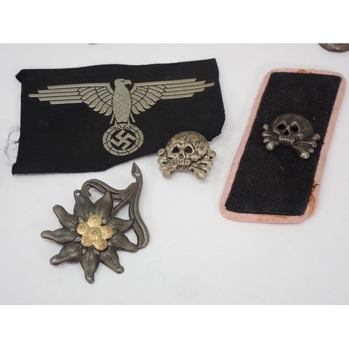 1299 - A collection of German Third Reich metal and cloth Badges