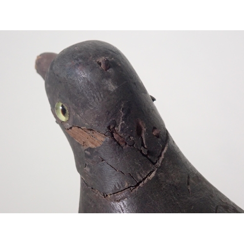 1358 - An antique wooden painted full bodied Pigeon Decoy with carved beak and inset glass eyes (A/F), 5 1/... 