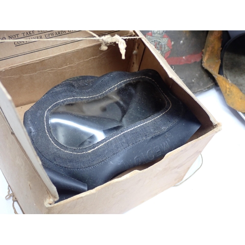 1487 - Two WWII Brodie Helmets, a Warden's Helmet, a Gas Mask in box and a pair of leather Gaiters