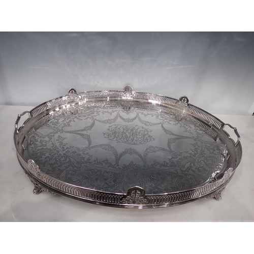 100 - An impressive Victorian silver oval Gallery Tray engraved leafage swags, central initials, raised on... 