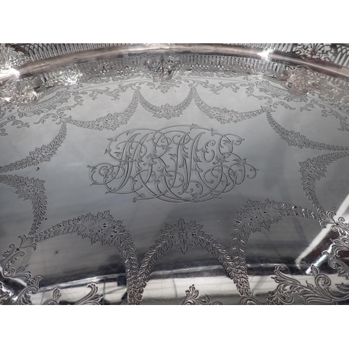 100 - An impressive Victorian silver oval Gallery Tray engraved leafage swags, central initials, raised on... 