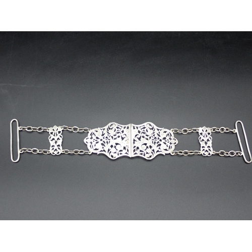 11 - A Victorian silver two part Nurse's Buckle with pierced and engraved floral scroll design, with chai... 