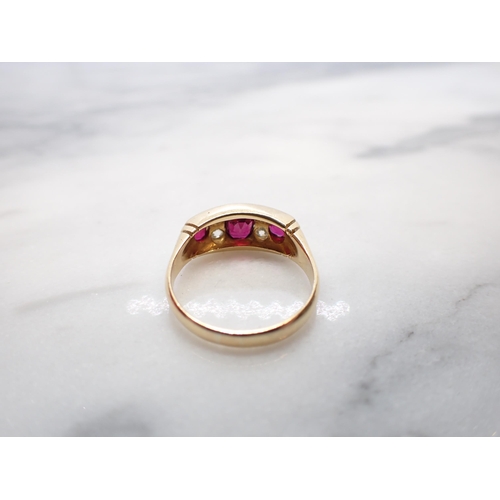 146 - An Edwardian Ruby and Diamond Ring pavé-set three graduated oval-cut rubies with pairs of old-cut di... 