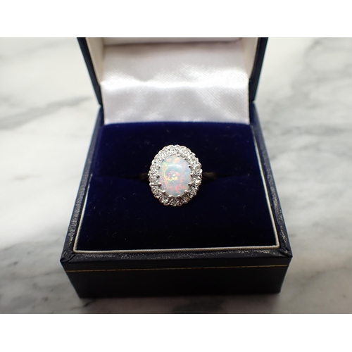 157 - An Opal and Diamond Cluster Ring claw-set oval opal cabochon within frame of eight-cut diamonds, sta... 