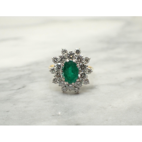 190 - An Emerald and Diamond Cluster Ring claw-set oval-cut emerald within double frame of brilliant-cut d... 