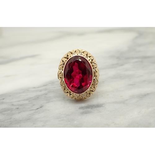 192 - A synthetic Ruby Dress Ring set oval-cut stone in pierced frame, tests as 14ct, ring size Q, approx ... 