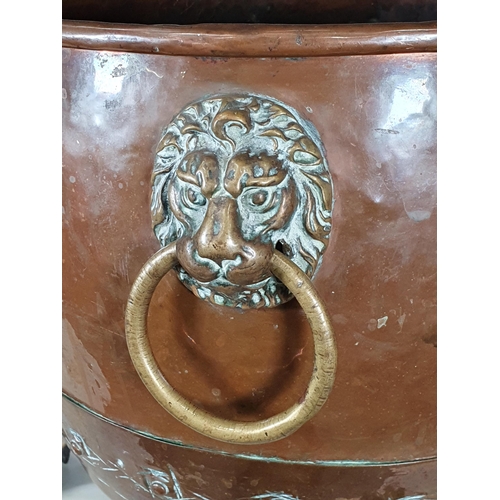 365 - An antique copper Log Cauldron with lion mask ring handles, raised on paw supports, 15